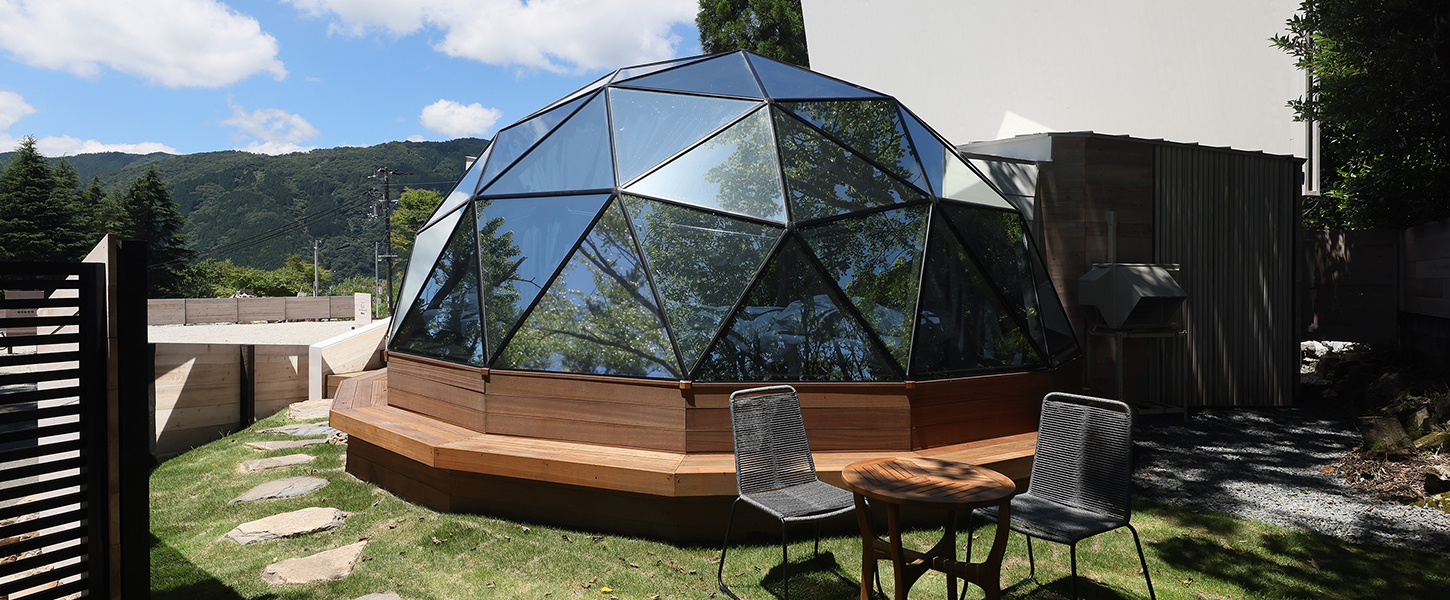 晴天の空と山並みを背景に佇む、カロひめKotiのドーム型宿泊棟